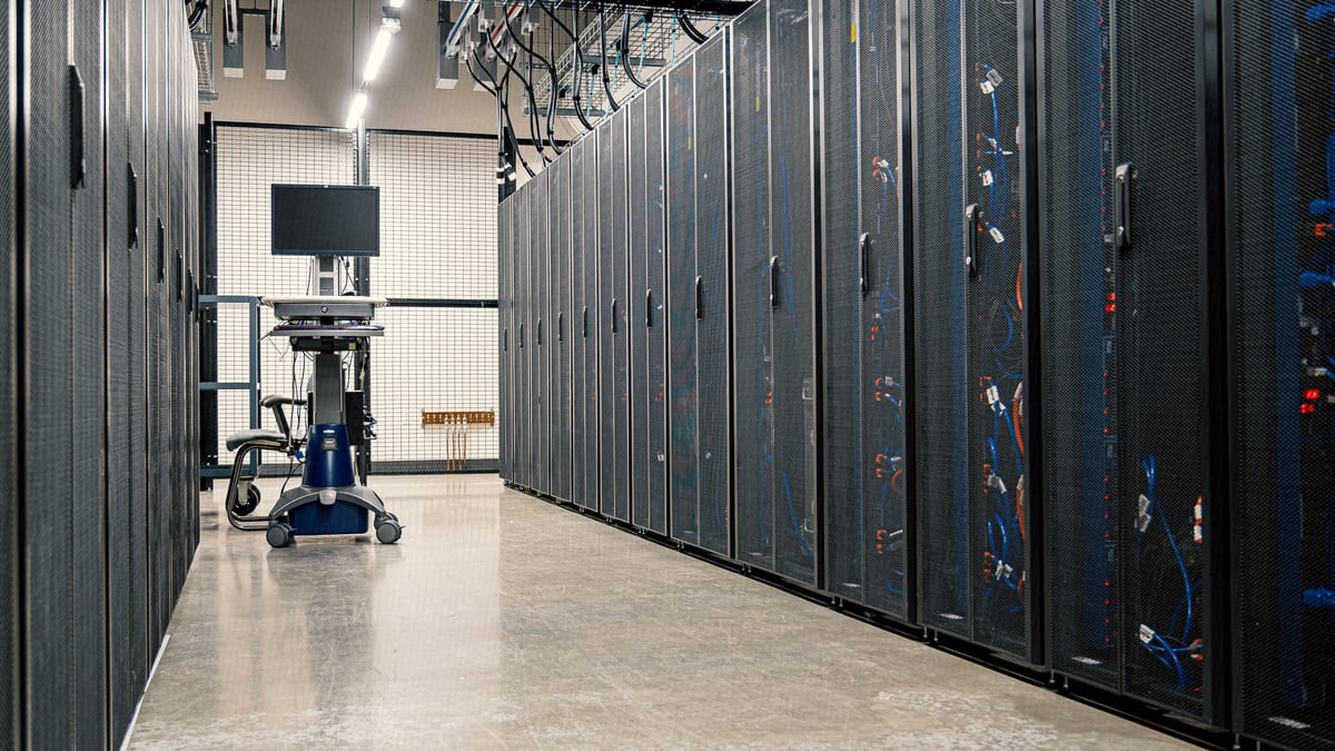 A data center corridor lined with server racks and cabling, evoking the structured, automated parsing behind an ATS.